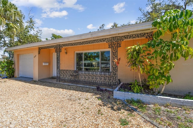 single story home featuring covered porch and a garage