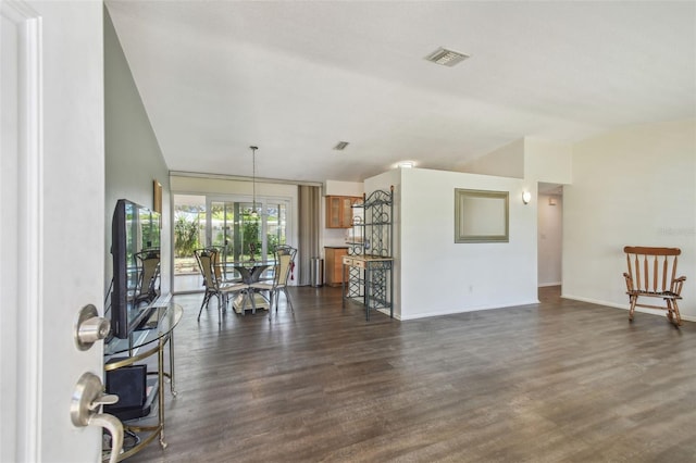 unfurnished living room featuring dark wood finished floors, baseboards, visible vents, and a chandelier