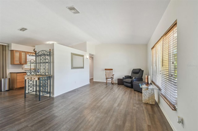 sitting room featuring visible vents, dark wood-type flooring, and baseboards