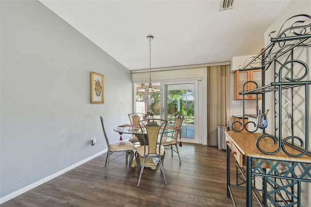 dining room featuring visible vents, baseboards, a notable chandelier, and wood finished floors