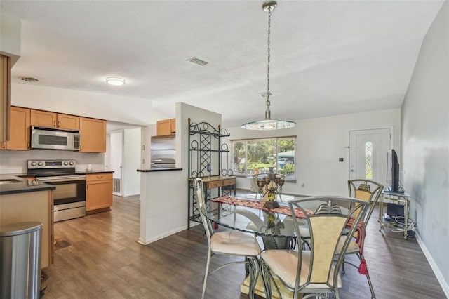 dining room featuring vaulted ceiling, dark wood-style floors, visible vents, and baseboards