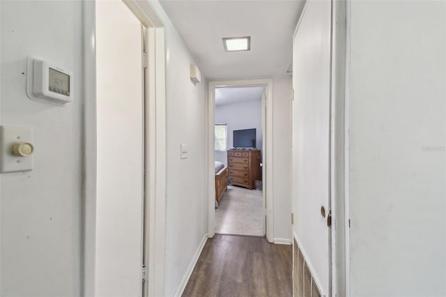 corridor featuring baseboards and wood finished floors