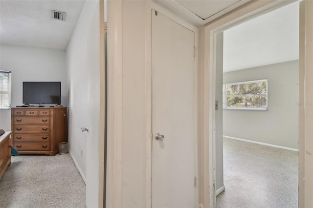 hall featuring visible vents and baseboards