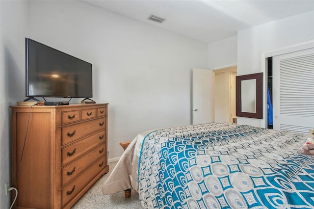 bedroom with visible vents, speckled floor, and a closet