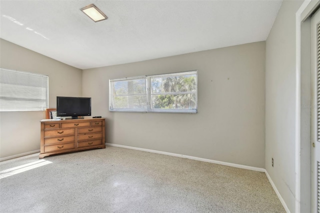 bedroom with speckled floor and baseboards