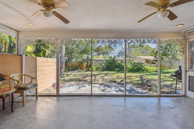 unfurnished sunroom with a ceiling fan