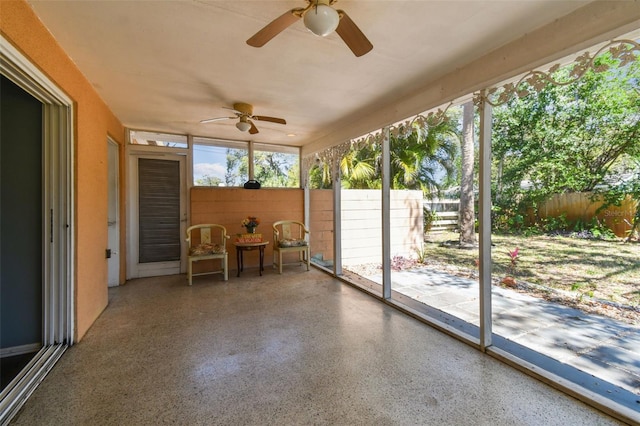 unfurnished sunroom featuring a ceiling fan