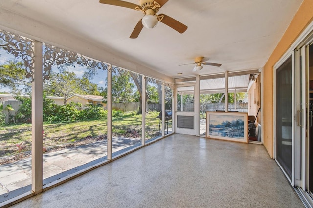 unfurnished sunroom with ceiling fan