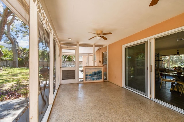 unfurnished sunroom with ceiling fan