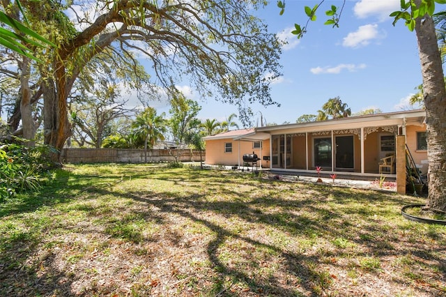 view of yard with a sunroom and fence