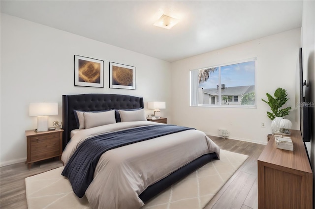 bedroom featuring light wood-style flooring and baseboards