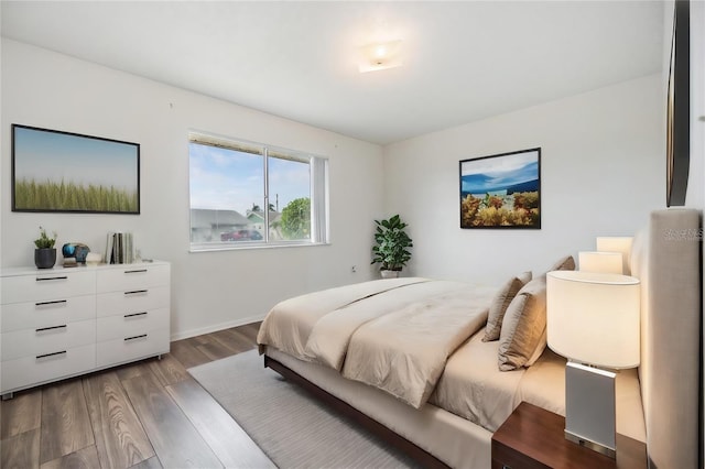 bedroom with baseboards and wood finished floors