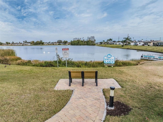 exterior space featuring a lawn and a water view