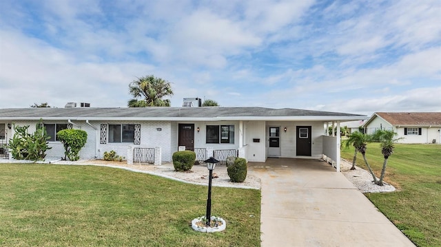 ranch-style home with a carport, driveway, brick siding, and a front yard