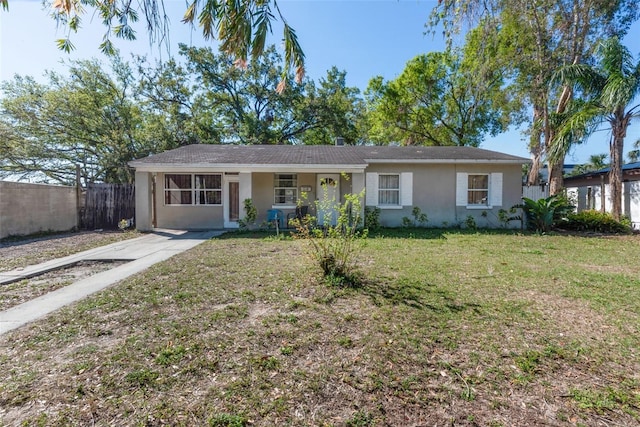 ranch-style home with a front yard, fence, and stucco siding