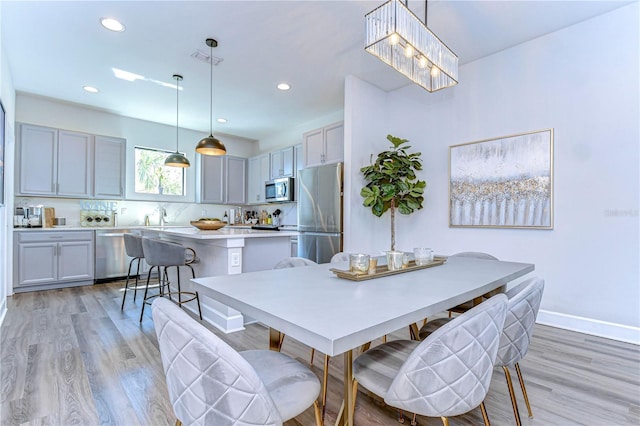 dining room featuring light wood-style flooring, recessed lighting, baseboards, and visible vents