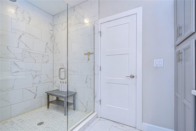 bathroom featuring marble finish floor and a shower stall