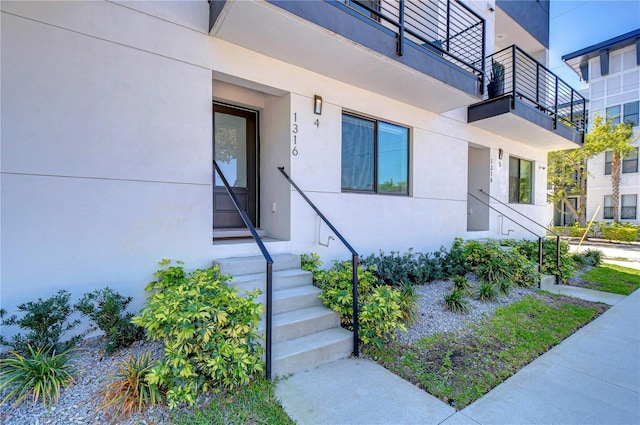 doorway to property featuring stucco siding