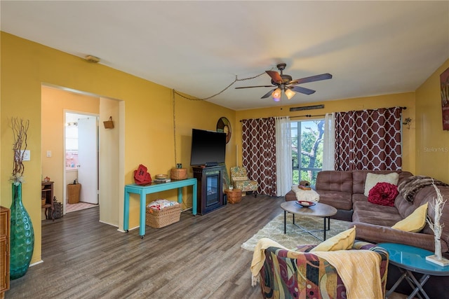 living room with a fireplace, a ceiling fan, and wood finished floors