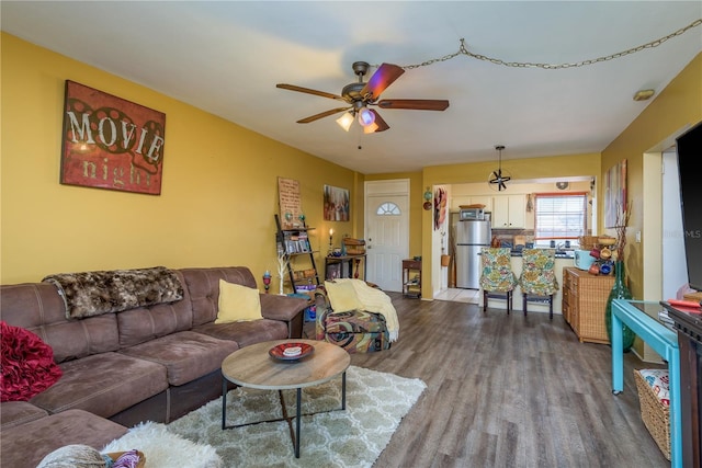 living area featuring a ceiling fan and dark wood-style flooring