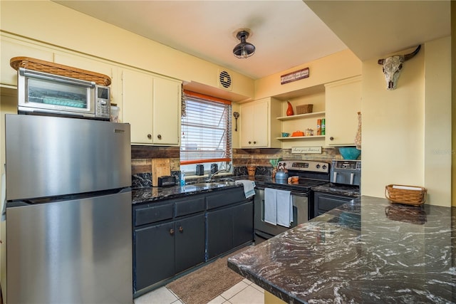 kitchen featuring dark stone countertops, open shelves, light tile patterned flooring, white cabinets, and appliances with stainless steel finishes