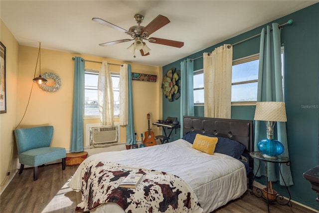 bedroom featuring ceiling fan, cooling unit, and wood finished floors