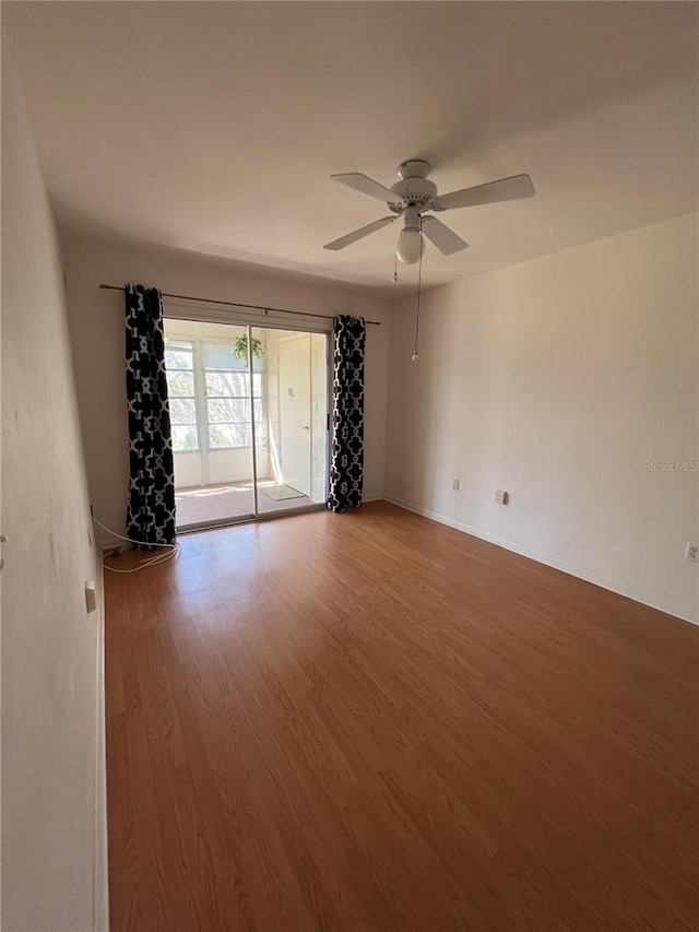 spare room with wood finished floors and ceiling fan