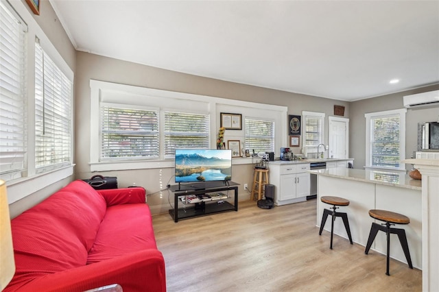 living area featuring recessed lighting, light wood-style flooring, and a wall mounted AC