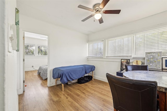 bedroom with a ceiling fan, light wood-type flooring, and baseboards