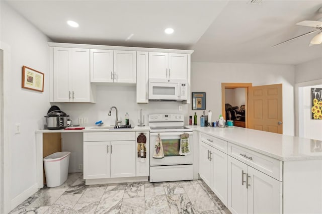 kitchen featuring light countertops, a peninsula, white appliances, white cabinetry, and a sink