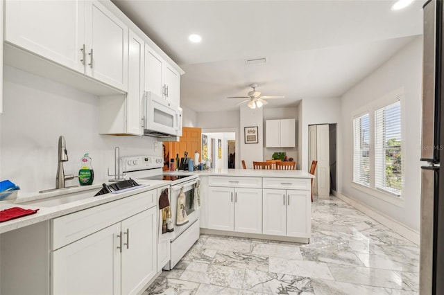 kitchen featuring marble finish floor, a sink, white appliances, a peninsula, and light countertops