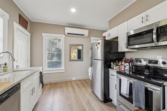 kitchen featuring a wall mounted air conditioner, appliances with stainless steel finishes, crown molding, and a sink