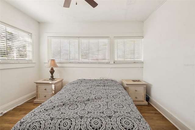 bedroom with ceiling fan, baseboards, and wood finished floors