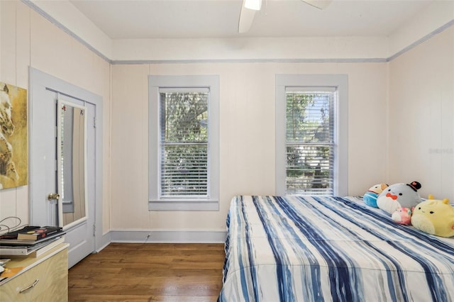 bedroom featuring wood finished floors, baseboards, and ceiling fan