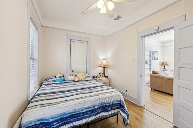 bedroom featuring visible vents, a ceiling fan, and light wood-style floors