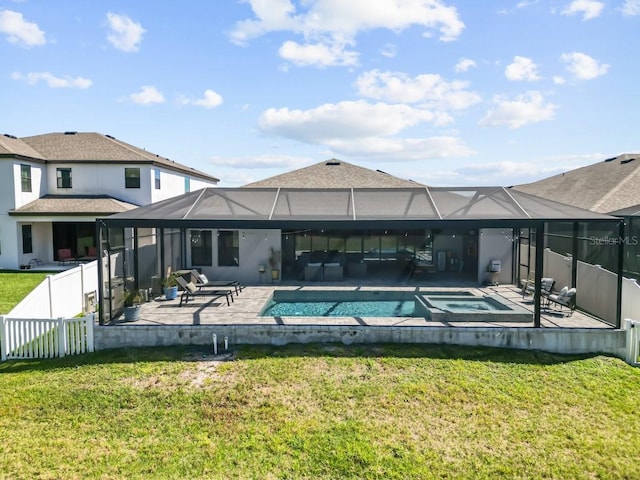 back of property featuring a patio area, a lawn, an in ground hot tub, and fence