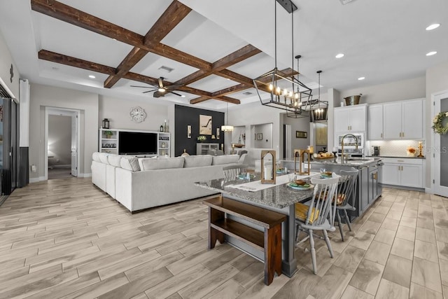 interior space with beam ceiling, coffered ceiling, and wood finish floors