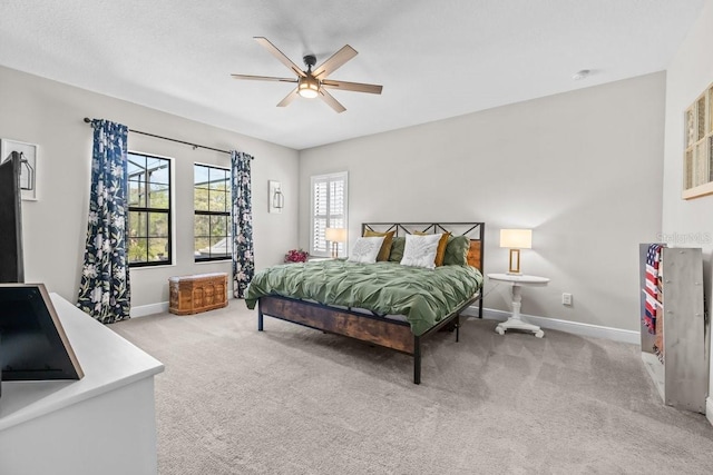 carpeted bedroom with a ceiling fan and baseboards