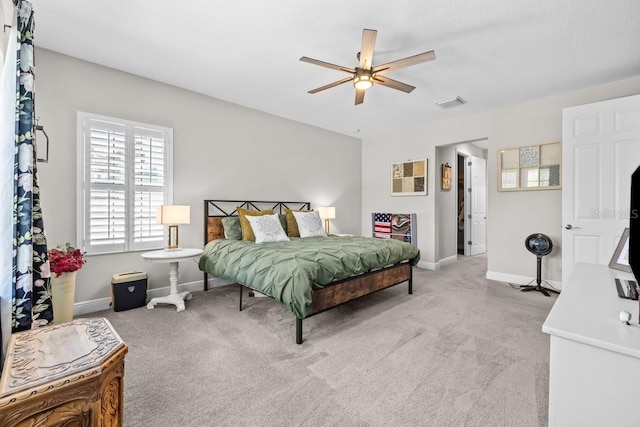 bedroom featuring visible vents, light colored carpet, and baseboards