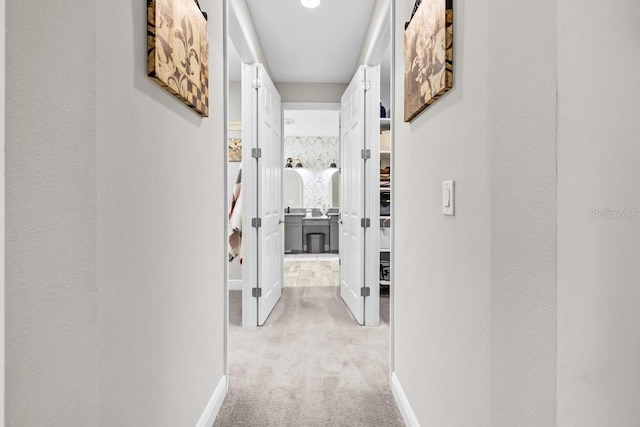 corridor featuring carpet flooring and baseboards