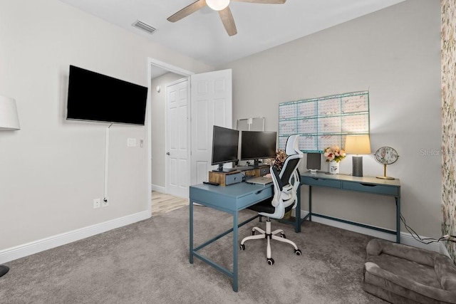 carpeted home office with a ceiling fan, visible vents, and baseboards