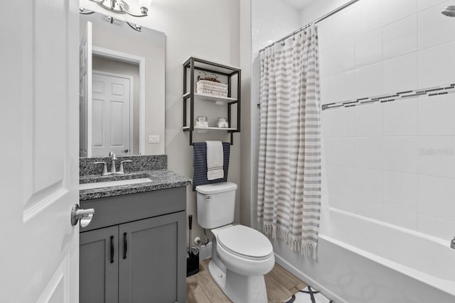 bathroom with shower / bathtub combination with curtain, toilet, wood finished floors, baseboards, and vanity