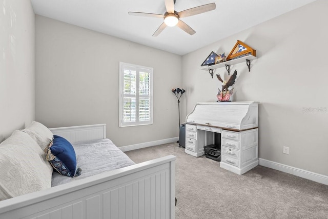 bedroom featuring baseboards, light colored carpet, and a ceiling fan