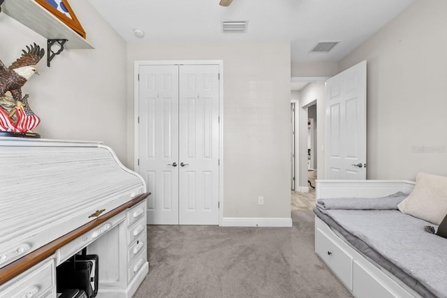 bedroom featuring light carpet, visible vents, baseboards, and a closet