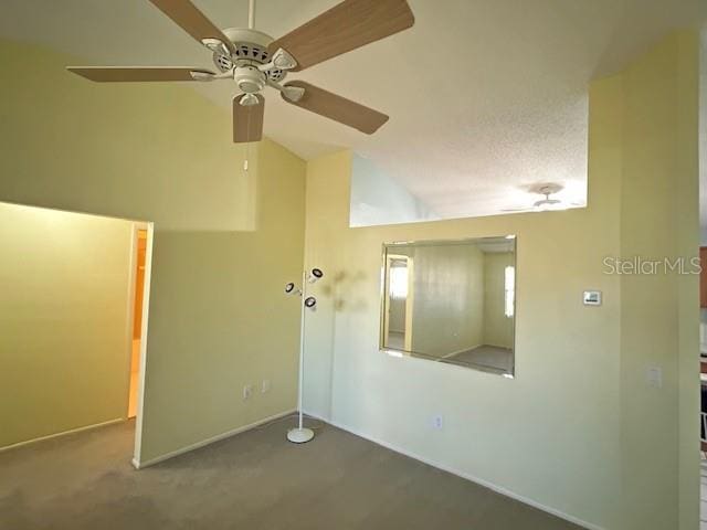 carpeted spare room featuring lofted ceiling and ceiling fan