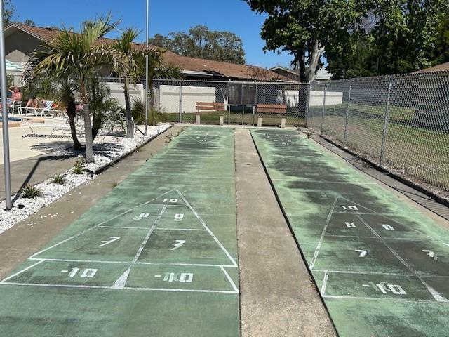 view of home's community featuring shuffleboard and fence