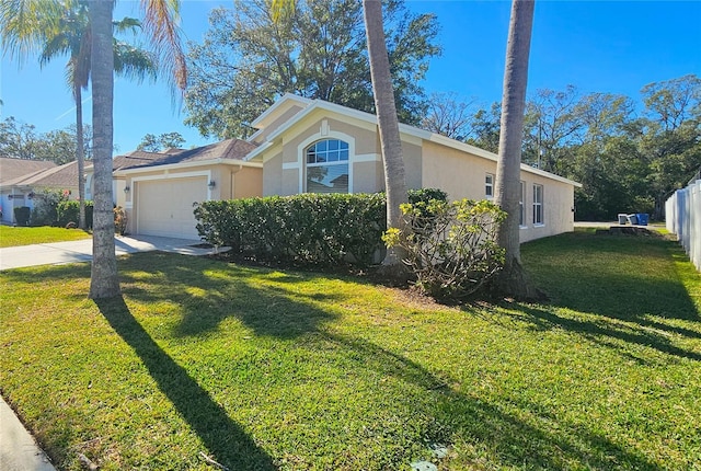 view of front of property featuring fence, a front yard, stucco siding, a garage, and driveway