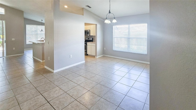 unfurnished room with light tile patterned floors, visible vents, lofted ceiling, and a wealth of natural light