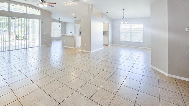 spare room with light tile patterned floors, baseboards, lofted ceiling, and ceiling fan