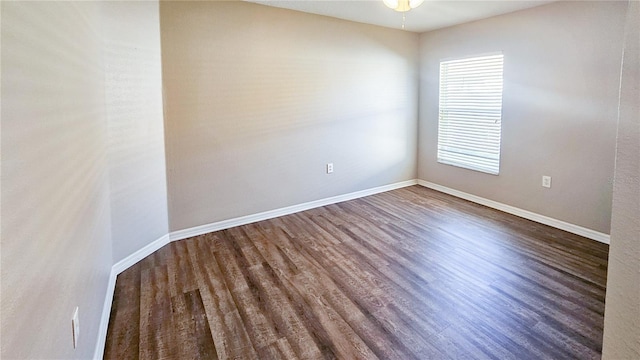 spare room featuring baseboards, wood finished floors, and a ceiling fan